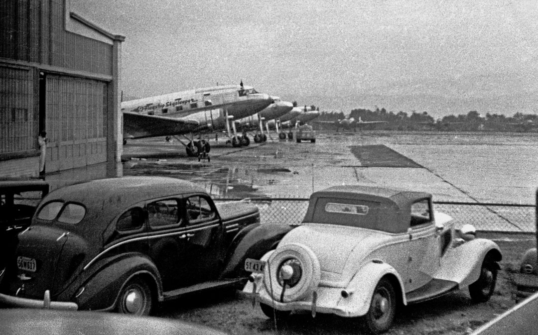 I believe this is Burbank airport on a rainy day in the early 1940s.  The DC3 first in the line is an American Airlines Flagship Skysleeper.  These aircraft were equipped with individual berths and required approximately 17 hours to fly coast to coast.  

Photo: Don Hall, Sr.

Don Hall
Yreka, CA